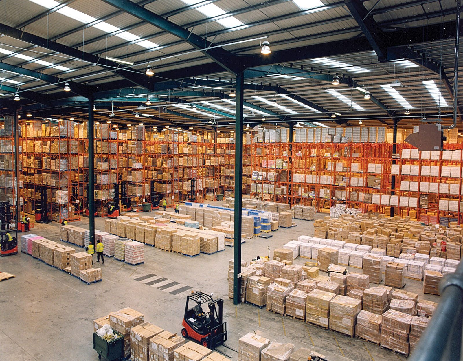 Entrepôt logistique avec racks, palettes et chariot élévateur, stockage de marchandises